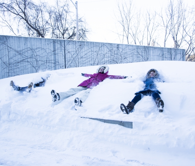 students making snow angels in front of the Perimeter Institute building