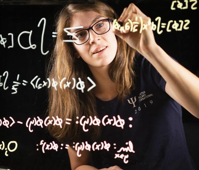 researcher writing equations on a transparent window