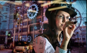 Woman wearing a hard hat and writing equations on a clear board with machinery behind her