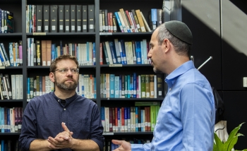 Two men talking in library 