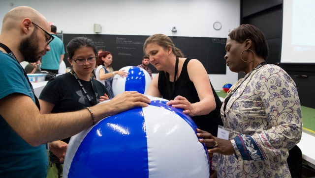 Four teachers working together on an activity with a beach ball